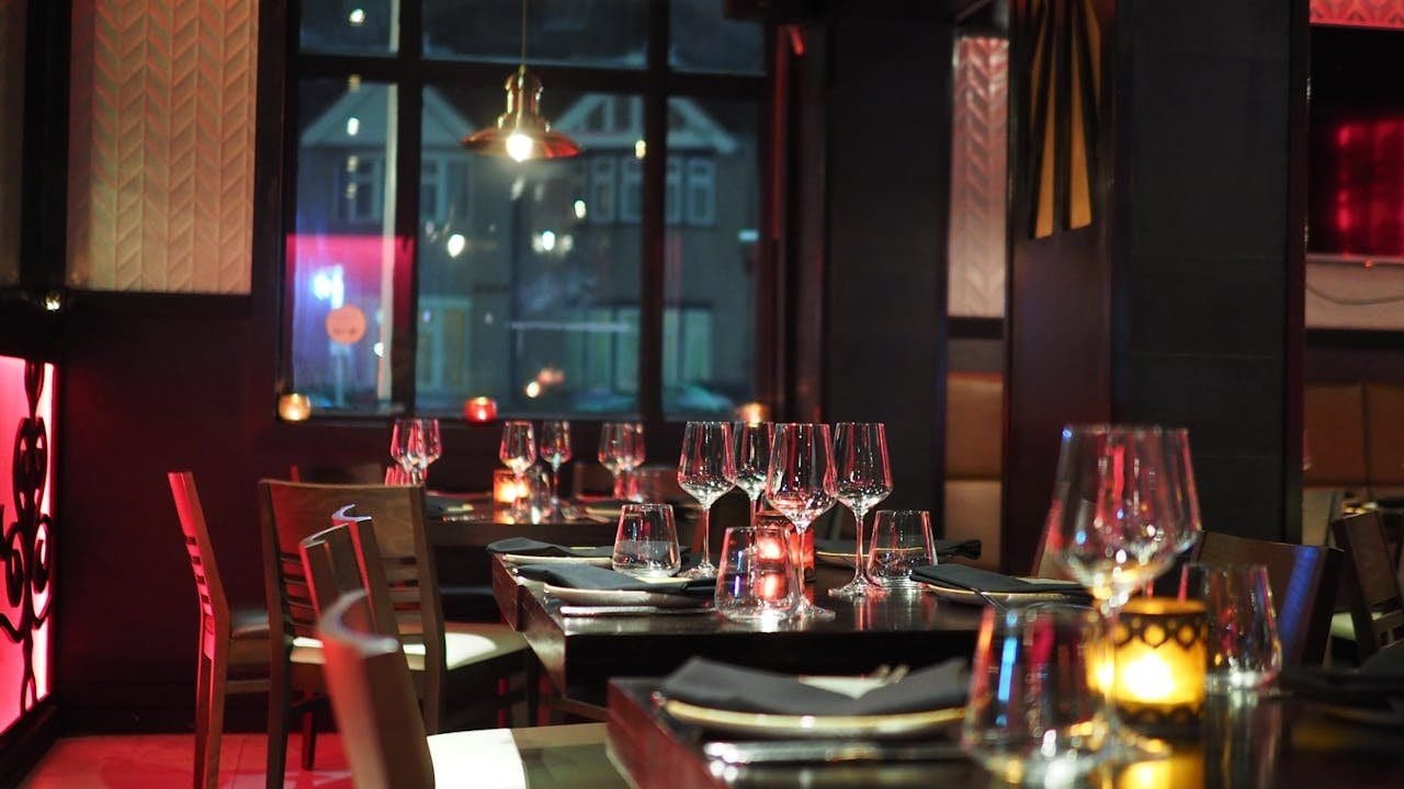 Interior de un restaurante con mesas preparadas y luz cálida